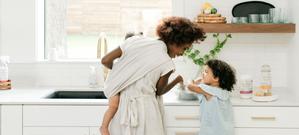 Mother washing clothing stains with daughter